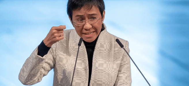 Maria Ressa is delivering her Nobel Prize Lecture and making an emphatic gesture.